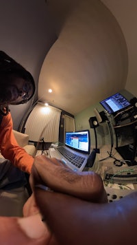 a man is sitting in a room with a laptop